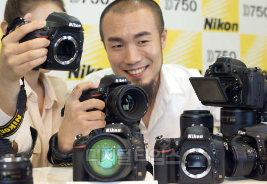 12일 서울 중구 코리아나호텔에서 열린 니콘의 신형 DSLR 카메라 D750 발표 행사에서 그룹 체리필터의 손스타가  D750을 선보이고 있다. 이번에 출시한 D750은 니콘 FX 포맷 DSLR 카메라 중 최초로 틸트식 액정 모니터를 탑재한 모델로 유효 화소수 2432만 화소의 니콘 FX 포맷 CMOS 센서와 화상 처리 엔진 EXPEED4를 탑재했다. 유동일기자 eddieyou@
